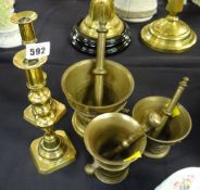 Three brass pestle & mortars together with a pair of brass candlesticks