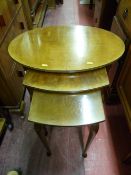 Oval topped walnut nest of three tables