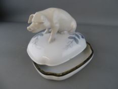 Royal Copenhagen porcelain box and cover formed as a seated pig, the base and lid rim banded in