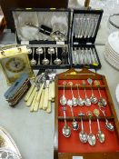 Cased cutlery set, commemorative diecast tram, carriage clock, souvenir spoons on a rack etc