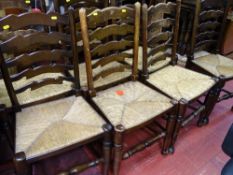 Chunky oak twin flap dining table and a set of eight rush seated ladderback dining chairs