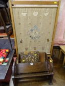 Two vintage book racks, an acorn carved lidded box and a needlework panel firescreen decorated