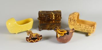 FIVE EARTHENWARE / SLIP CURIOS comprising two cradles, a small bird, rocking horse model and a piano