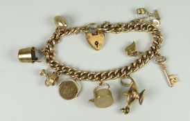 9CT GOLD CURB LINK CHARM BRACELET with heart shaped padlock & assorted charms to include genie lamp,