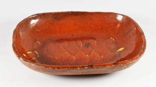 A SLIPWARE BAKING DISH with worn cream slip decoration, believed 19th Century, 31cms long
