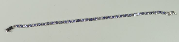 A 9CT WHITE GOLD TANZANITE TENNIS-BRACELET
