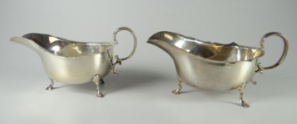 PAIR OF GEORGE V SILVER SAUCE BOATS having pie crust edge rim, C-scroll handles & raised on three