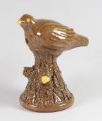 AN EARTHENWARE AND SLIP BIRD WHISTLE the bird perched upon a conical bark textured bough, believed