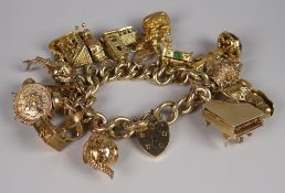 A 9CT GOLD CURB LINK BRACELET with heart shaped padlock & an assortment of fifteen charms to include