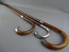 THREE VINTAGE WALKING STICKS, two having hallmarked silver collars and handle tips, the other with