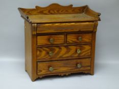 A VICTORIAN PITCH PINE APPRENTICE CHEST of five drawers, the rectangular top with splashback rail,