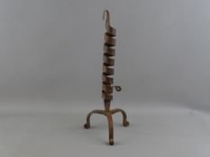 AN ANTIQUE WROUGHT IRON COURTING CANDLE HOLDER having a spiral twist column on a tripod base and