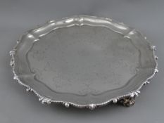 A WAVY EDGE THREE FOOTED SILVER SALVER, London 1883, 17.5 troy ozs, 16.5 cms diameter (monogrammed)
