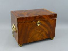 A GEORGIAN MAHOGANY TEA CADDY, rectangular form with ring handles on brass bun feet, with inlaid