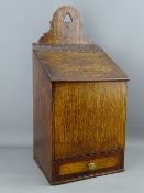 AN ANTIQUE OAK CANDLEBOX with crossbanded base drawer, 47.5 cms high, 22.5 cms wide, 18.5 cms deep