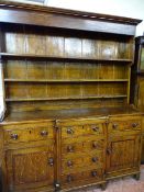 A MID 19th CENTURY ANGLESEY OAK BREAKFRONT DRESSER, wide boarded rack over a well coloured panel