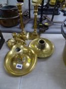 Two brass chambersticks, a pair of candlesticks and a brass match striker