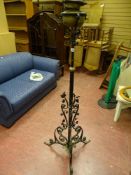 Vintage oil lamp on black metal stand with scrollwork and floral leaf decoration