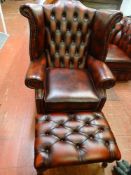 Wing back red leather armchair and a footstool