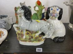 Staffs pottery zebra, a clock spillholder and one other and a seated spaniel holding a basket of
