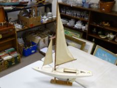 Model yacht on stand with sails, 77 cms long