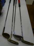 Four vintage golf clubs including Ping etc