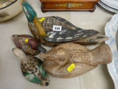 Four carved wooden ducks, three having painted decoration