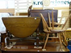 Ercol twin flap gate leg dining table and two light wood stickback chairs