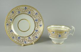 A SWANSEA PORCELAIN TEA CUP & SAUCER decorated with blue flowers and berries on gilded vines