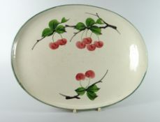 A LLANELLY POTTERY CABARET TRAY of oval form, painted with cherries, marked Llanelly to base,