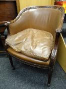 A Howard & Sons elbow chair with half moon cushion seat, curved back & with carved arms having