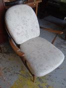 An Ercol fleur-de-lys & spindle back cushion seated armchair