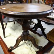 A reproduction circular top tripod table