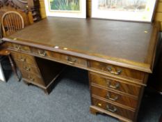 A very good reproduction mahogany pedestal desk composed of nine drawers on bracket feet, panel