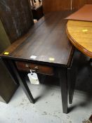 An antique drop-flap oak table with drawer