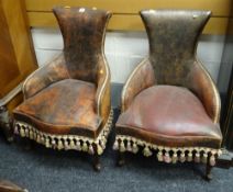 A pair of small unusual vintage leather chairs with studded arms & tasselled fringes, possibly