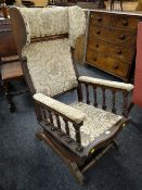 A vintage American-type sprung rocking wingback armchair