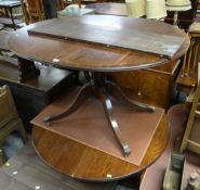A reproduction circular mahogany extending dining table together with a circular oak extending