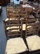 A set of six rush seated ladder back chairs, three Ercol arched back Prince of Wales feather
