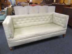 An antique Knowle-type sofa of rectangular form in believed original green fan-pattern buttoned