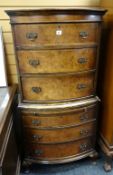 An antique-reproduction bow front tall boy of six drawers, 136cms high