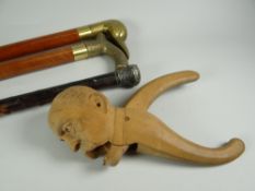 A novelty mustached-man's head novelty nut cracker & three walking sticks