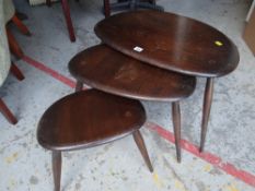 A nest of three mid-century Ercol 'Pebble' tables in dark wood