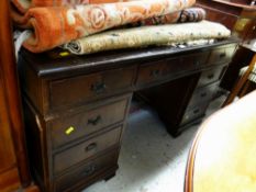 A reproduction desk with tooled leather top & a bank of nine drawers