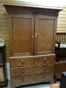 An antique oak press cupboard with a base of two long & two short drawers