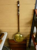 Polished wall hanging rack in the Arts & Crafts style and a brass long handled bedwarming pan