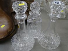 Pair of circular based glass decanters with stoppers and a square based glass decanter with stopper