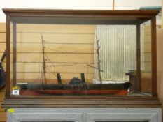 Model of a paddle boat steamer in a glass display case