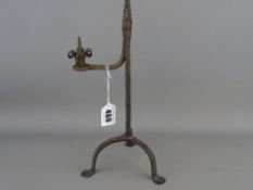 Late 18th Century rush light holder on a tripod base and with interesting scrolled handle