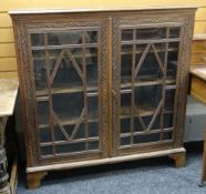 A vintage oak carved & glazed bookcase on bracket feet, 115cms wide Condition Report: please